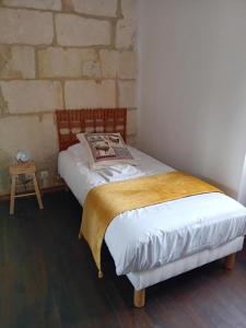 a bed in a room with a brick wall at Le chene vert in Saint-Front-de-Pradoux
