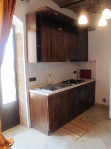 eine Küche mit Holzschränken und einem Waschbecken in der Unterkunft Mozzafiato Pitigliano in Pitigliano