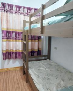 a bedroom with two bunk beds and a window at Ag-agongan Lodge in Baguio
