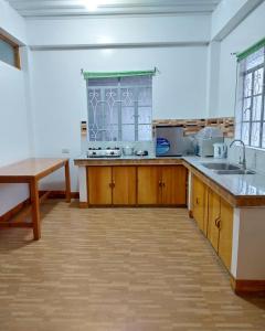 a large kitchen with wooden cabinets and a sink at Ag-agongan Lodge in Baguio