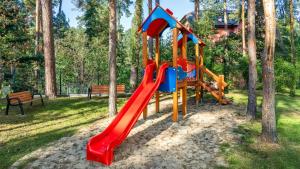 a playground with a slide in a park at Stegna Park II blisko morza Apartamenty Piamola in Stegna