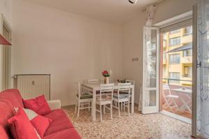 ein Wohnzimmer mit einem roten Sofa und einem Tisch in der Unterkunft Peace House - Relax a Due Passi dal Mare in Finale Ligure