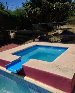 a large swimming pool with a blue pool at CABAÑAS SANTA RITA - Tanti, Córdoba in Tanti