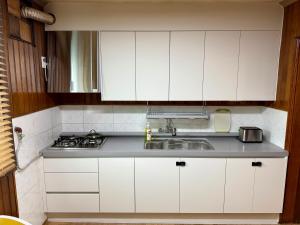 P'aengsŏngSlow Stay, Camp Humphreys的带白色橱柜和水槽的厨房 更多8张照片