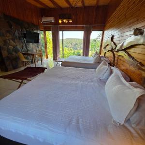 a large bed in a room with a window at Tupa Lodge Selva y Rio in Puerto Iguazú