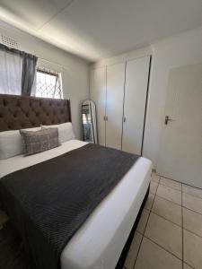 a bedroom with a large bed with a black blanket at Zolas guest house in Mthatha