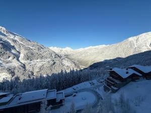 ein Haus im Schnee mit Bergen im Hintergrund in der Unterkunft Élégant Duplex - Sainte Foy Station - 10 pers in Sainte-Foy-Tarentaise