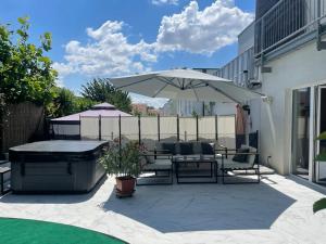 a patio with a table and an umbrella at Wohlfühlhaus mit Jacuzzi, Fitness, Infrarotkabine, Kamin, Piano, tolle Lage in Vienna