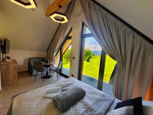 a bedroom with a large bed with a large window at Willa Pienińska 123 in Maniowy
