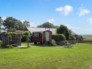 una casa con tavolo da picnic in cortile di Glan Tywyn Shepherds Hut a Caeʼr-geiliog Altre 5 foto