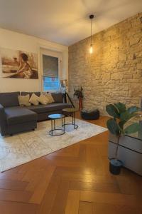 a living room with a couch and a brick wall at Cool and Laidback at Sankt Johann in Basel
