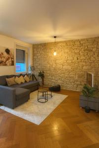 a living room with a couch and a stone wall at Cool and Laidback at Sankt Johann in Basel +1 photo