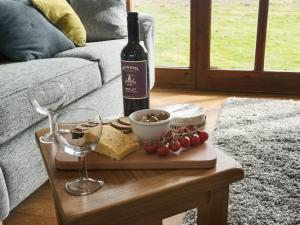 a bottle of wine and wine glasses on a table at Elm Tree Barn in Felmingham