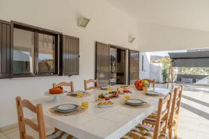 une salle à manger avec une table et des chaises blanches dans l'établissement Ma-la Beach House by HostWise, à Marinhas