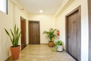 einen Flur mit zwei Topfpflanzen und zwei Türen in der Unterkunft Hotel Supreme in Gurgaon