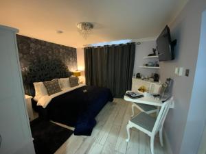 利明顿THE KNIGHTWOOD OAK a Luxury King Size Bed - En-Suite Space - LYMINGTON NEW FOREST with Totally Private Entrance - Key Box entry - Free Parking & Private Outdoor Seating Area - Town ,Shops , Pubs & Solent Way Walking Distance & Complimentary Breakfast的一间卧室，配有一张床和一张带电脑的书桌