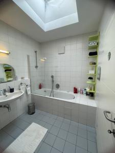 a white bathroom with a tub and a sink at Wohlfühlhaus mit Jacuzzi, Fitness, Infrarotkabine, Kamin, Piano, tolle Lage in Vienna +37 photos