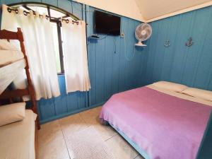 a blue room with a bed and a fan at Recanto Ana Valentin in Ilha do Mel +16 photos