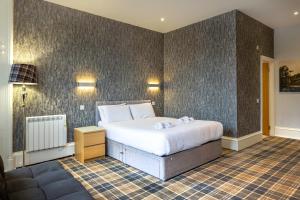 ein Schlafzimmer mit einem großen weißen Bett in einem Zimmer in der Unterkunft Crown Hotel & Bar in Inverness