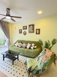 a living room with a green couch and a table at Tea Valley & Farm View at Cool Summer Cameron in Cameron Highlands