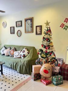 a living room with a christmas tree with presents at Tea Valley & Farm View at Cool Summer Cameron in Cameron Highlands
