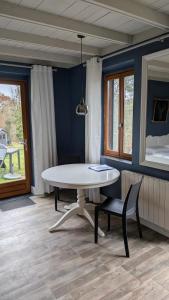 Saint-Julien-de-LamponBonBon Chambre d'hôtes的一间设有白色桌子和椅子的用餐室