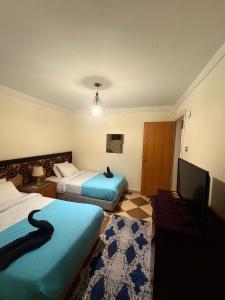 una habitación de hotel con dos camas y un televisor de pantalla plana en Villa Sela Gem, en El Cairo 8 fotos más