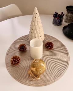 鲍纳塔尔Bauna Suites & Apartments的桌子上放着一个盘子，盘子里有一支蜡烛和一棵圣诞树。