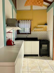 een keuken met witte kasten en een aanrechtblad bij casa celeste in Imbituba