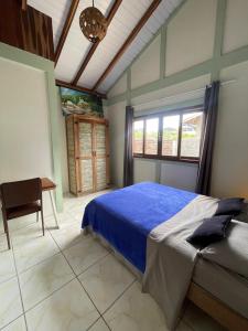 een slaapkamer met een bed en een bureau erin bij casa celeste in Imbituba