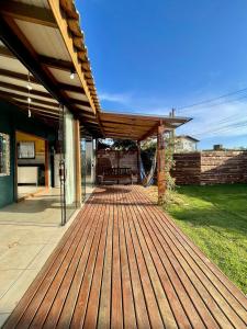 een houten terras met een bank op een huis bij casa celeste in Imbituba