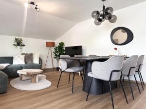 ein Wohnzimmer mit Tisch, Stühlen und Sofa in der Unterkunft Sunny Apartment 2 in Maria Alm am Steinernen Meer