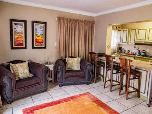 un soggiorno con due sedie e una cucina di Mistique Waters Guesthouse a Parys
