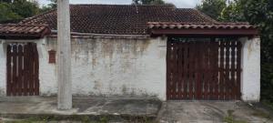 an entrance to a house with a wooden gate at Casa Mena Verão in Itanhaém