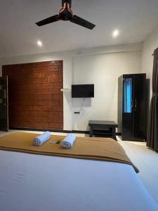 孟买Scarlet Resort的带床和吊扇的卧室