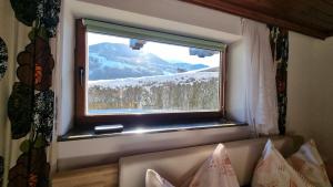 a window with a view of a snow covered mountain at Peaceful Mountain Double Room in Kleinsonnberg