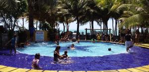 eine Gruppe von Personen in einem Pool mit Palmen in der Unterkunft Casa Mari Suites in Aracati