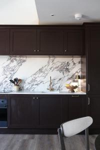 a kitchen with black cabinets and a marble counter top at Luxury Apartment in Shropshire sleeps 4 in Shrewsbury