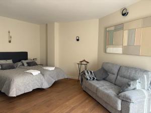 Casa Entremuseos في سمورة: غرفة معيشة بها أريكة وسرير