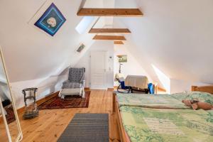 una camera mansardata con letto e sedia di Ferienwohnung Sannes a Welt
