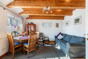 un soggiorno con un divano blu e un tavolo di Ferienwohnung Sannes a Welt