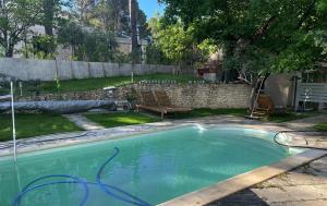 a swimming pool with a hose in a yard at Gîte du Jonquas in Velleron