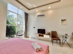 um quarto com uma cama rosa e uma televisão em Sea House Hotels and Apartments em Vung Tau