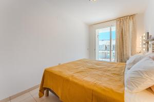 een slaapkamer met een bed met een groot raam bij Poseidon 9 - 1 bedroom apartment in Puerto de Santiago +7 foto's