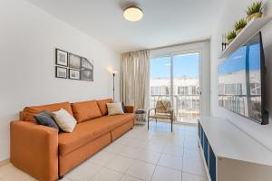 een woonkamer met een bank en een groot raam bij Poseidon 9 - 1 bedroom apartment in Puerto de Santiago