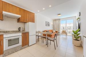een keuken met witte apparatuur en een tafel met stoelen bij Poseidon 9 - 1 bedroom apartment in Puerto de Santiago