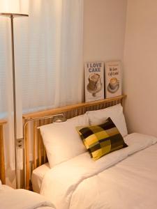 a bed with a yellow and black pillow on it at 아늑하고 조용한 신축 숙소 Stay Hyun301 in Seoul