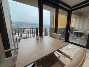 スコピエにあるPanoramic Penthouse Apt in Diamond of Skopjeのバルコニー付きの客室で、テーブルと椅子が備わります。