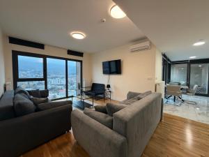 スコピエにあるPanoramic Penthouse Apt in Diamond of Skopjeのリビングルーム(ソファ2台、テレビ付)
