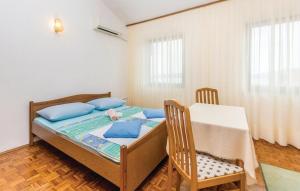 a bedroom with a bed and a table and chairs at Apartments with parking space Pinezici, Krk - 18967 in Vrh +32 photos